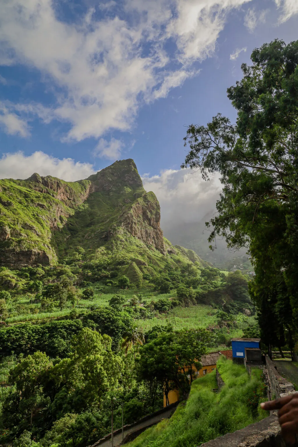 Een indrukwekkend zicht op een weelderige groene vallei met steile bergpieken onder een blauwe lucht op Santo Antão, Kaapverdië.