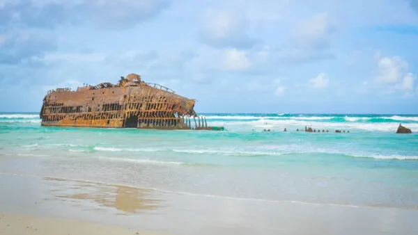 Het roestige scheepswrak van de Cabo Santa Maria op het zandstrand en in de turquoise zee van Boa Vista, Kaapverdië.