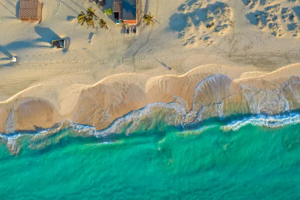 Turquoise zee, wit strand, palmbomen en een beachbarretje op eiland Sal