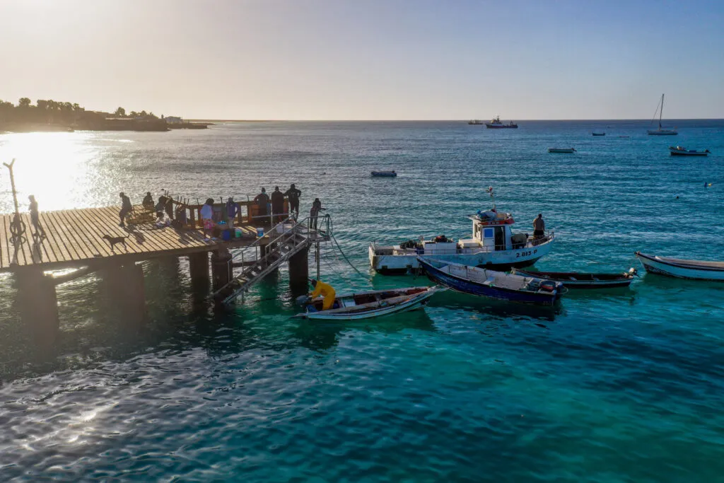 Houten vissersboten bij de steiger op het helderblauwe water van Santa Maria op het eiland Sal, Kaapverdië.