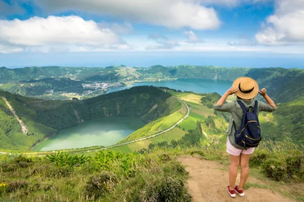 Een vrouwelijke reiziger kijkt tijdens een wandeling uit op het landschap van Sete Cidades op het eiland São Miguel