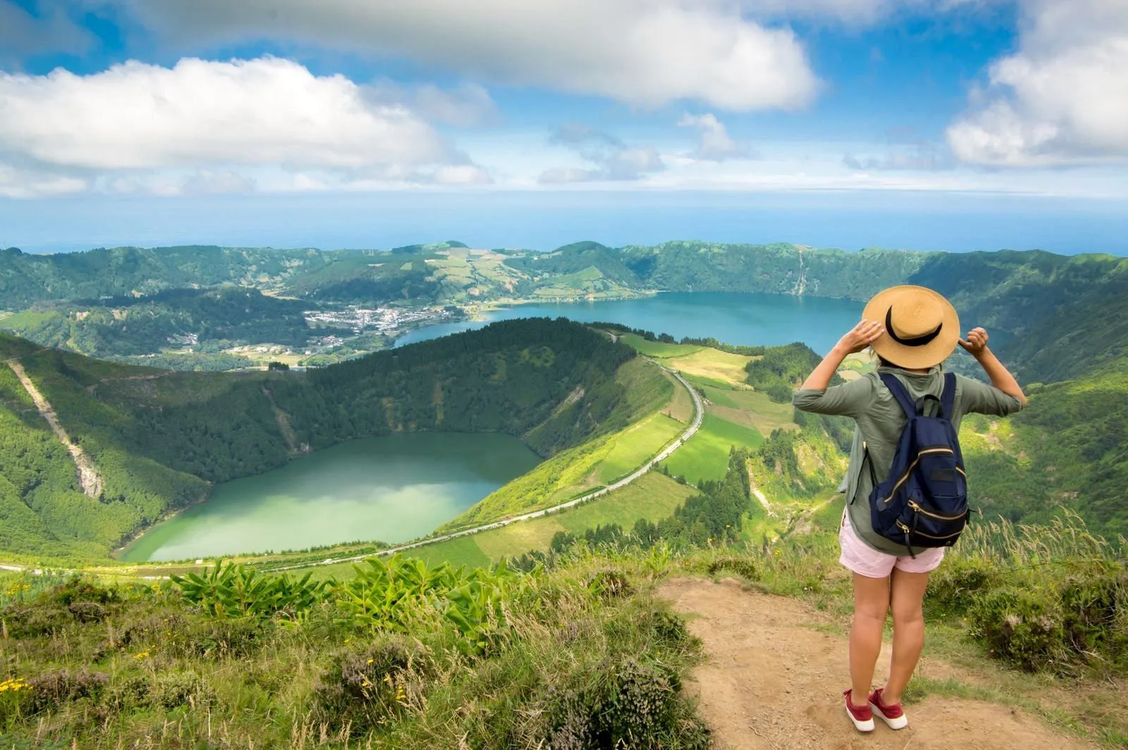 Een vrouwelijke reiziger kijkt tijdens een wandeling uit op het landschap van Sete Cidades op het eiland São Miguel