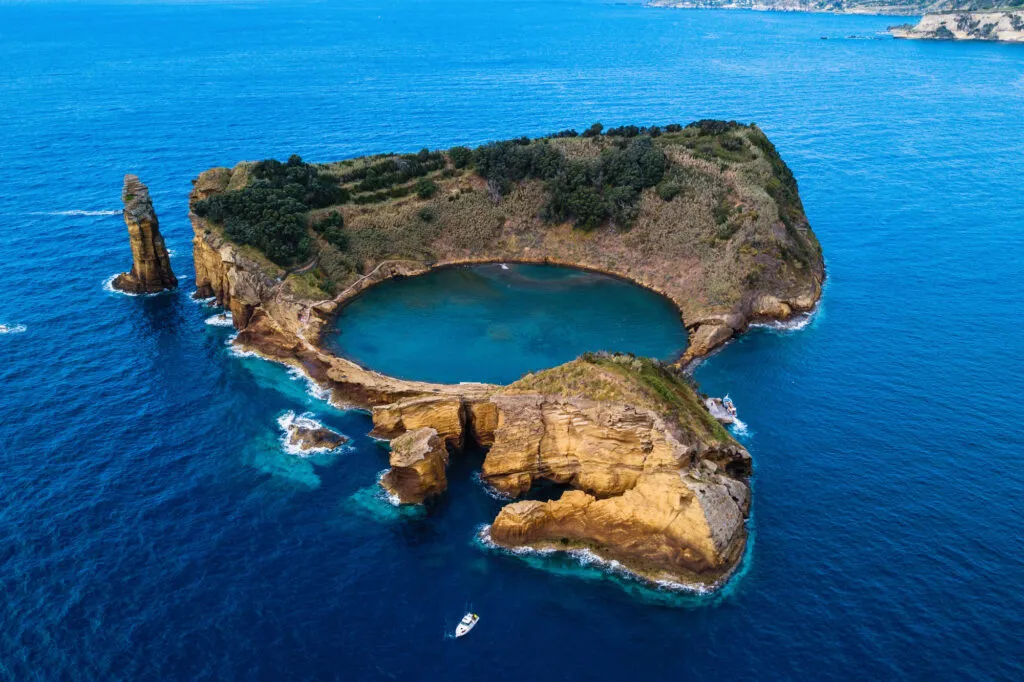 Perspectief van boven op het vulkanische krater-eilandje Ilhéu de Vila Franca do Campo met een perfect ronde, helderblauwe lagune in de Atlantische Oceaan.