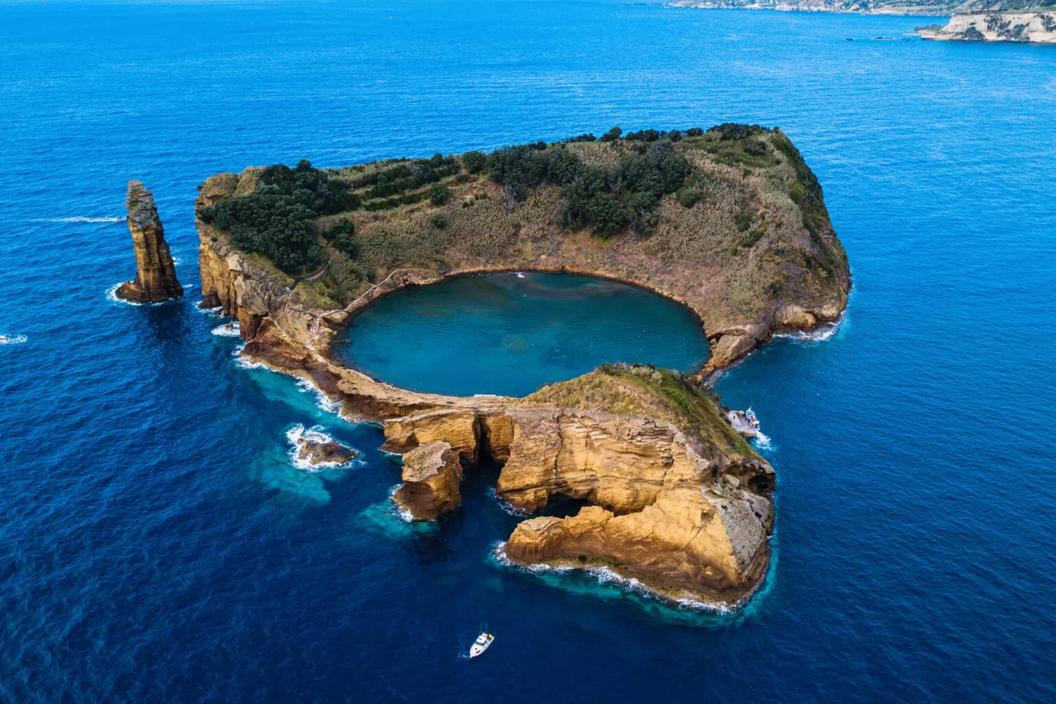 Perspectief van boven op het vulkanische krater-eilandje Ilhéu de Vila Franca do Campo met een perfect ronde, helderblauwe lagune in de Atlantische Oceaan.