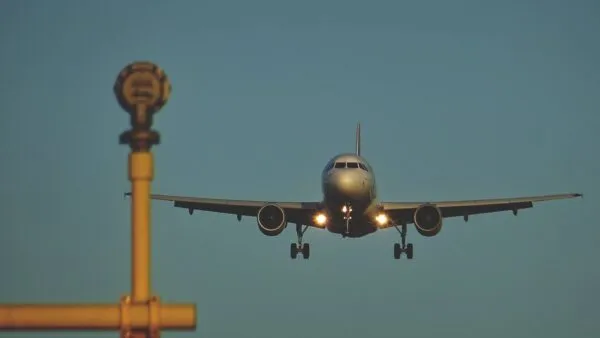 Een passagiersvliegtuig vliegt op lage hoogte met uitgeklapt landingsgestel en brandende koplampen richting de landingsbaan op de Azoren.