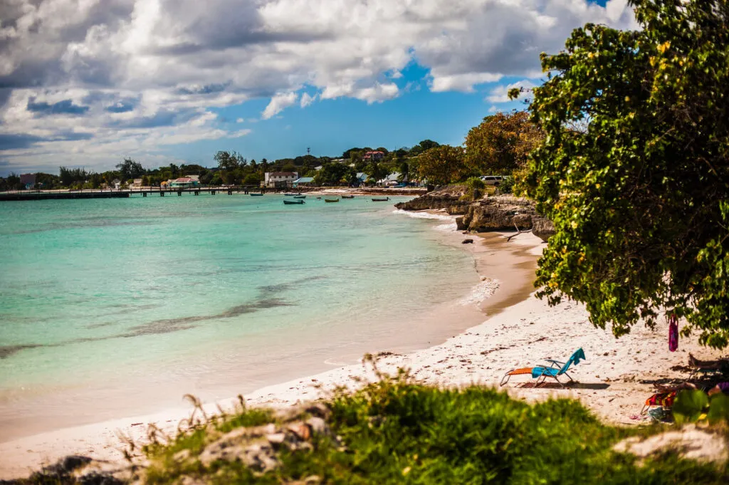 Blauw strandbedje op het witte zandstrand aan een heldere turquoise zee op Barbados.