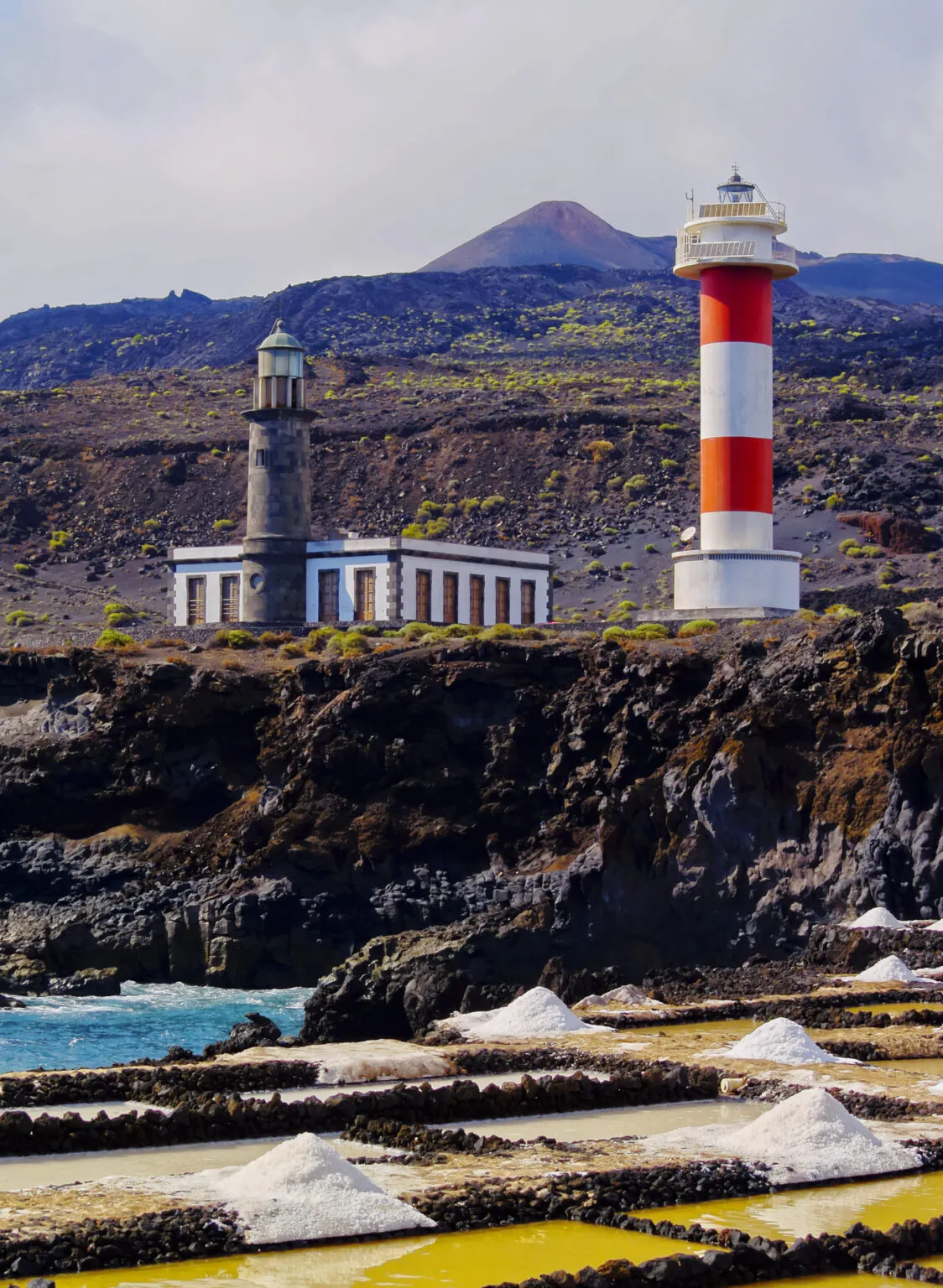 De historische stenen vuurtoren en de rood-wit gestreepte vuurtoren bij de zoutpannen aan de vulkanische kust van Fuencaliente op La Palma