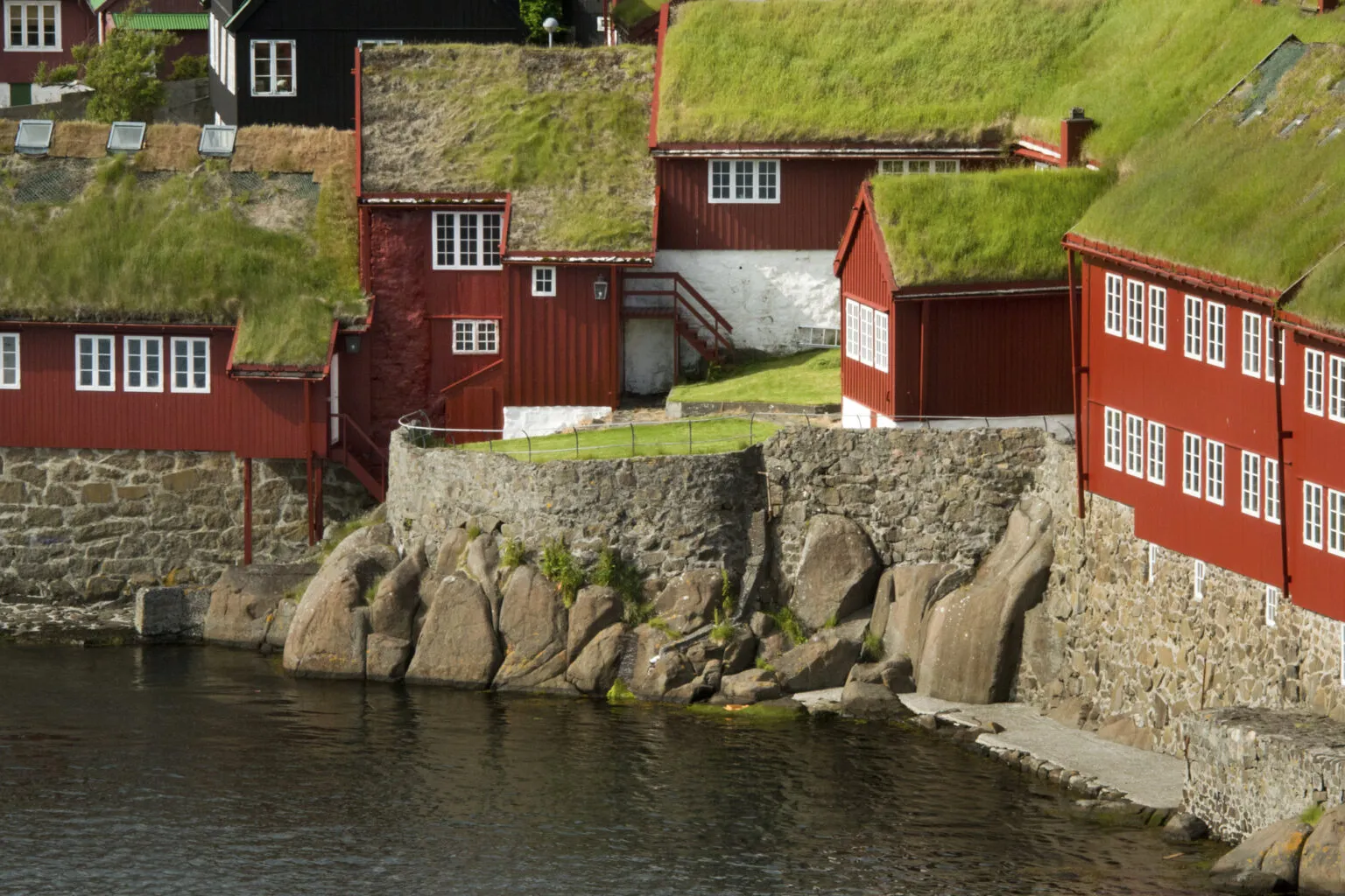 Rode gebouwen met traditioneel grasdak: het parlement van de Faeröer eilanden, gevestigd in hoofdstad Tórshavn