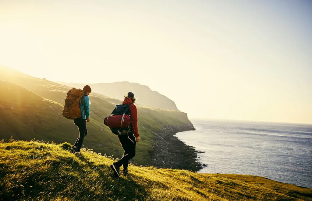 Reizigers hiken de Postman's Trail door de bergen van Vágar