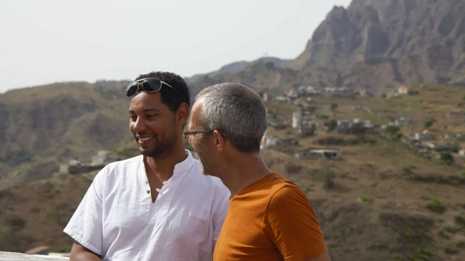 Joshua van Eijndhoven van Voja Travel en Etienne staan samen buiten met bergen op de achtergrond in Kaapverdië.