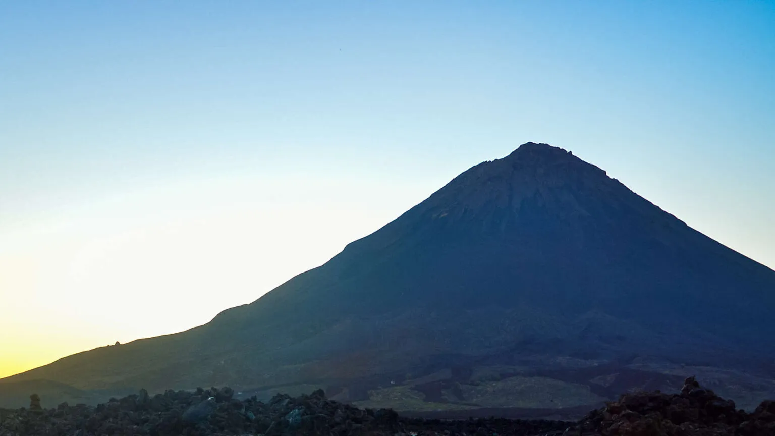 De steile helling van de vulkaan Pico do Fogo tekent zich af tegen een heldere blauwe lucht op Fogo in Kaapverdië.