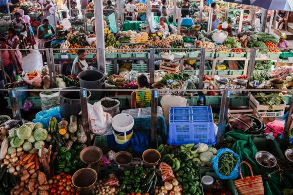 Overzichtsbeeld van een drukke overdekte markt met kleurrijke kramen vol verse groenten en fruit in Kaapverdië