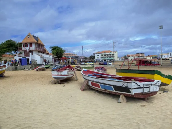 Kleurrijke traditionele vissersboten die op het droge zandstrand liggen nabij het centrum van Santa Maria op Sal, Kaapverdië.