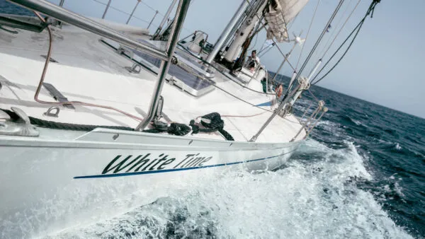 De zeilboot White Time snijdt schuin door de golven in de oceaan bij het eiland Sal in Kaapverdië.