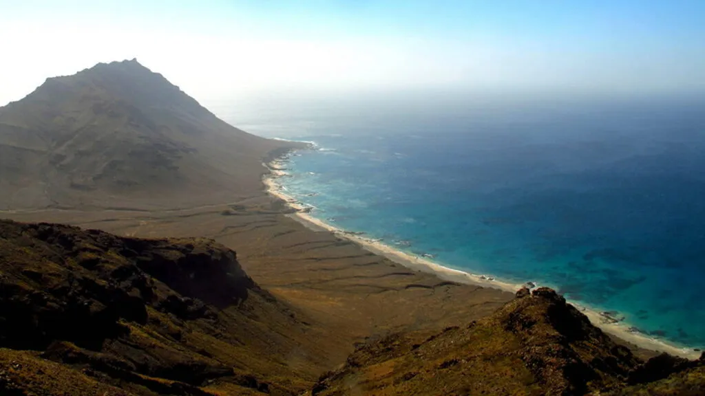 Panoramisch uitzicht vanaf de bergen op de onbewoonde kustlijn en heldere oceaan van Santa Luzia in Kaapverdië