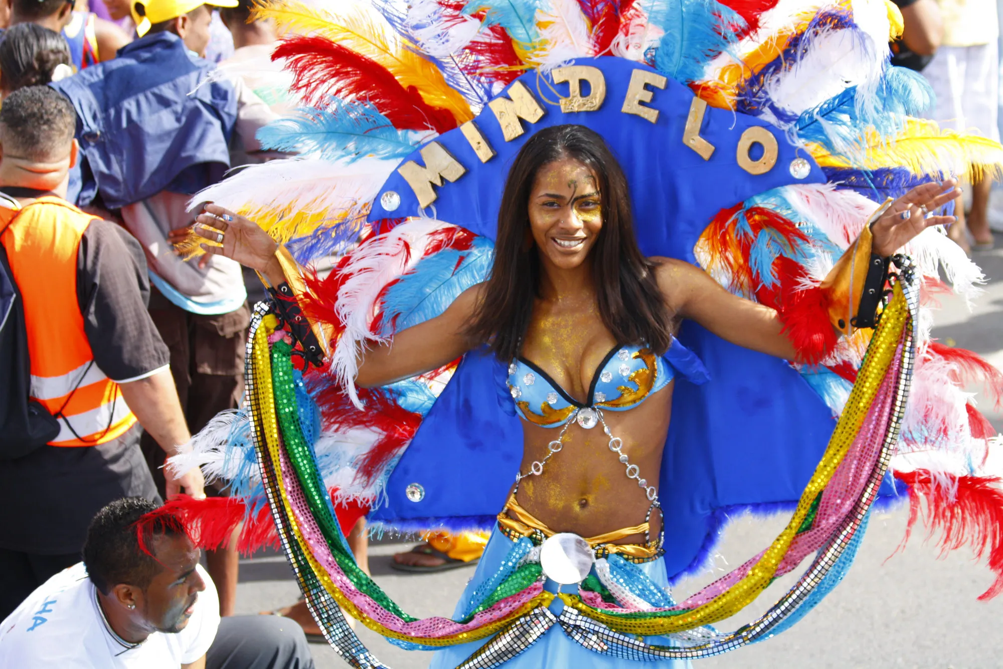 Een dansende vrouw in blauw kostuum en met grote hoofdtooi tijdens het Carnaval in Mindelo, de hoofdstad van São Vicente