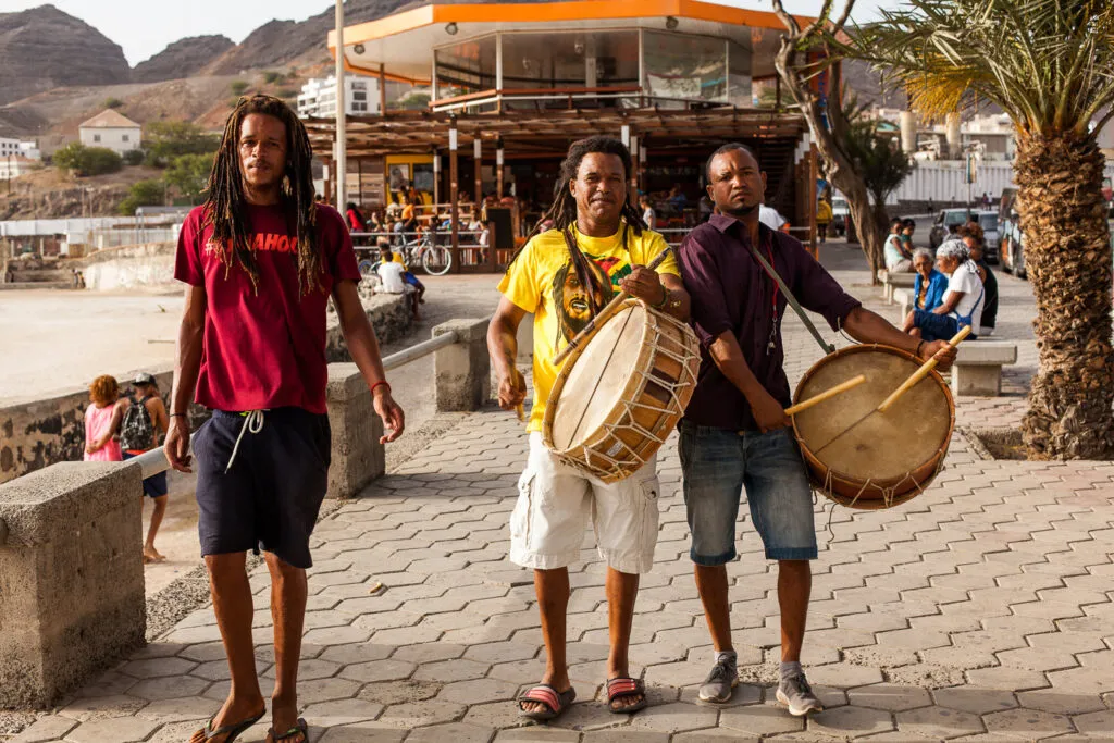 Drie lokale mannen maken muziek met trommels op straat op het eiland São Vicente, Kaapverdië.