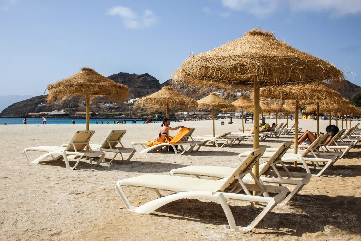 Zandstrand van Laginha met ligstoelen en rieten parasols op het eiland São Vicente in Kaapverdië.