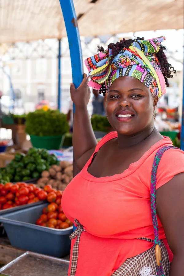 Een lokale vrouw kijkt lachend in de camera op een markt in hoofdstad Mindelo op eiland São Vicente, Kaapverdië