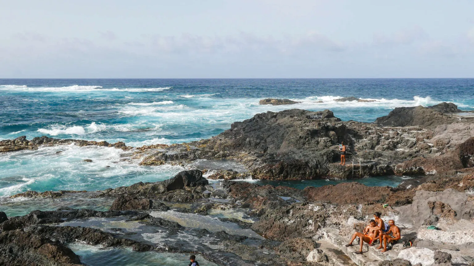 Wilde oceanische golven slaan tegen de zwarte vulkanische rotsen langs de kust van Santo Antão, Kaapverdië.