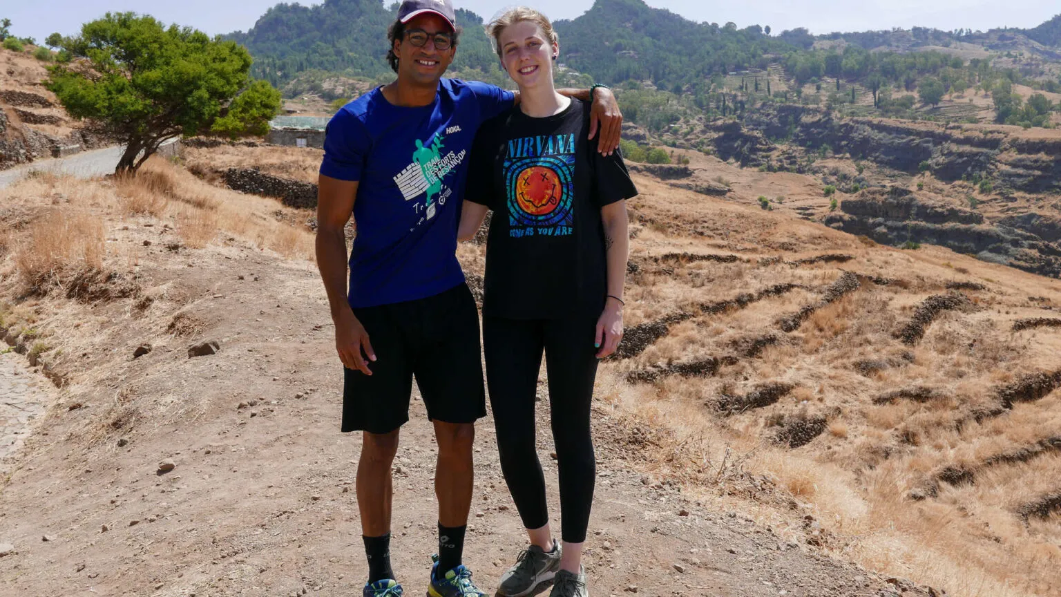 Een man en een vrouw staan arm in arm geposeerd op een pad in het bergachtige binnenland van Santo Antão, Kaapverdië.