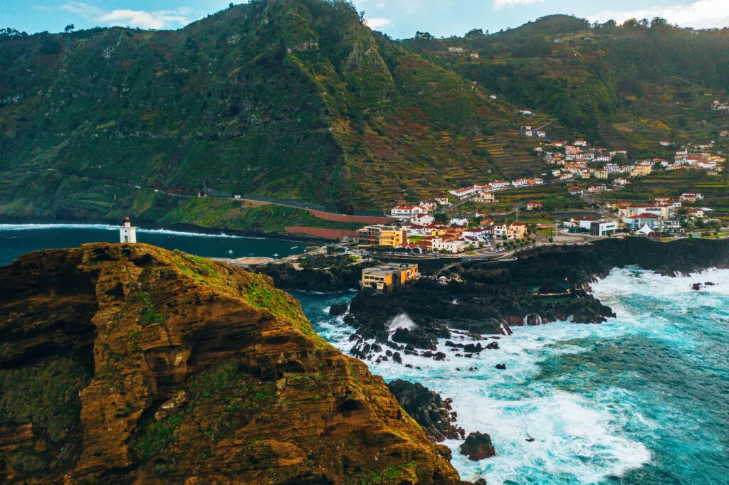Zicht op het kustdorp Porto Moniz met zijn beroemde vulkanische lavabadjes aan de ruige, wild brekende oceaan en groene bergen.