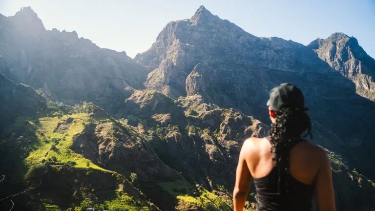 Een vrouw kijkt tijdens een hike uit over het bergachtige landschap van de binnenlanden van het eiland Santo Antão