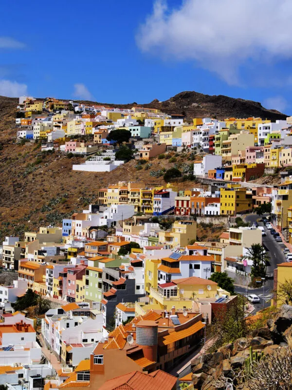 Een dichtbebouwde berghelling vol vrolijk gekleurde huizen in de hoofdstad San Sebastián op het eiland La Gomera.