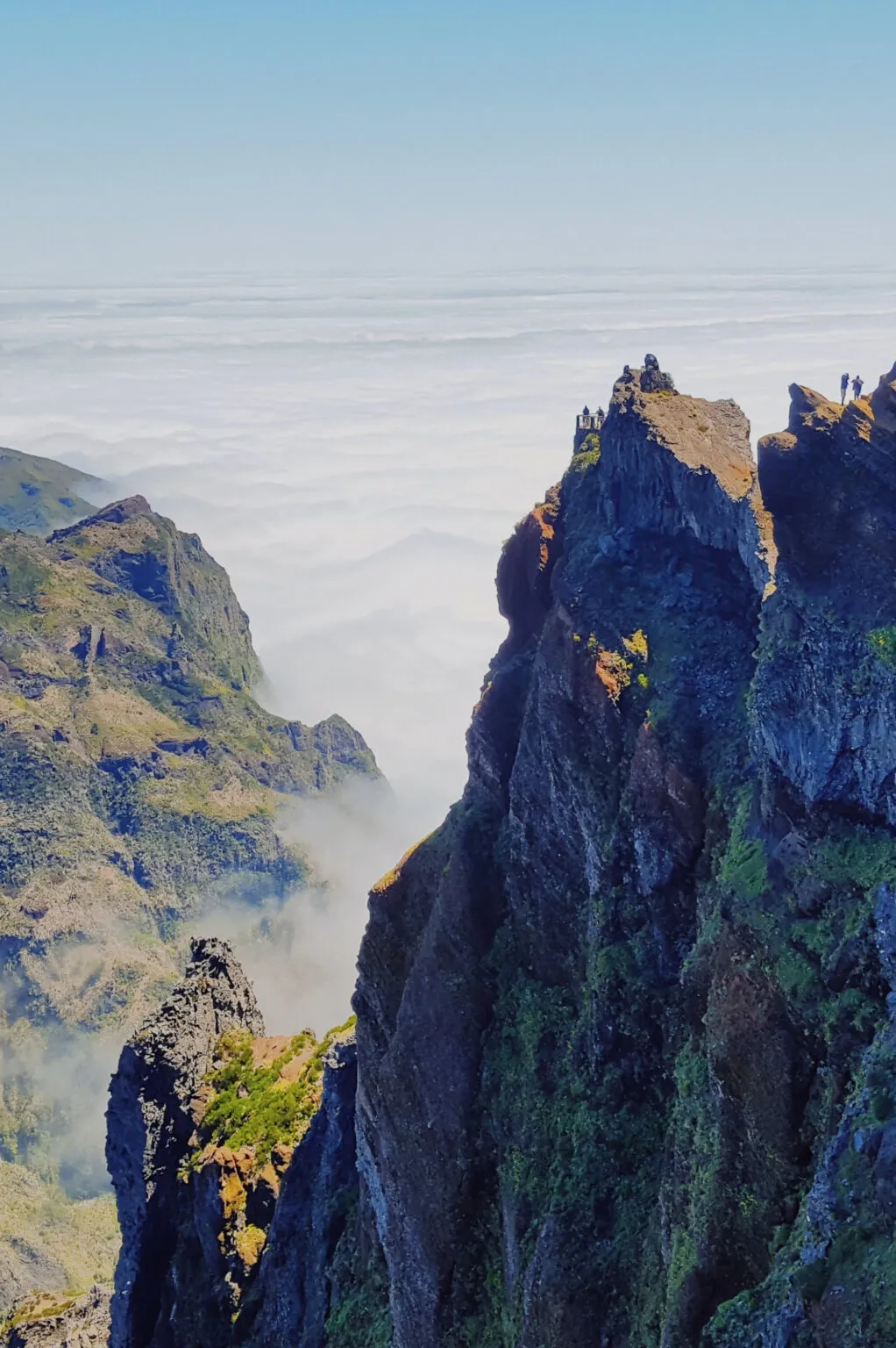 Ruige rotsachtige bergpieken steken uit boven een dicht wolkendek bij Pico Ruivo op Madeira
