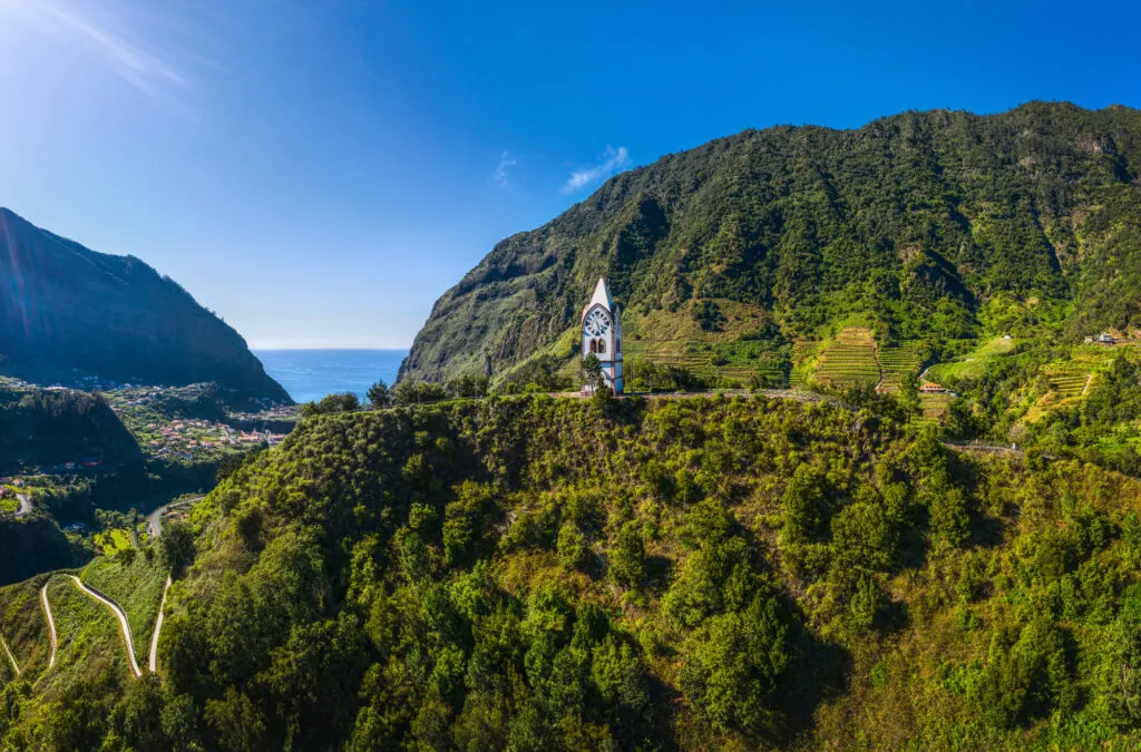 Witte kapel van Nossa Senhora de Fátima op een groenbegroeide heuveltop omgeven door steile bergen in de vallei van São Vicente op Madeira