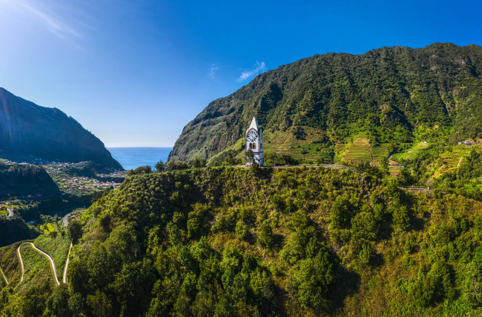 Witte kapel van Nossa Senhora de Fátima op een groenbegroeide heuveltop omgeven door steile bergen in de vallei van São Vicente op Madeira