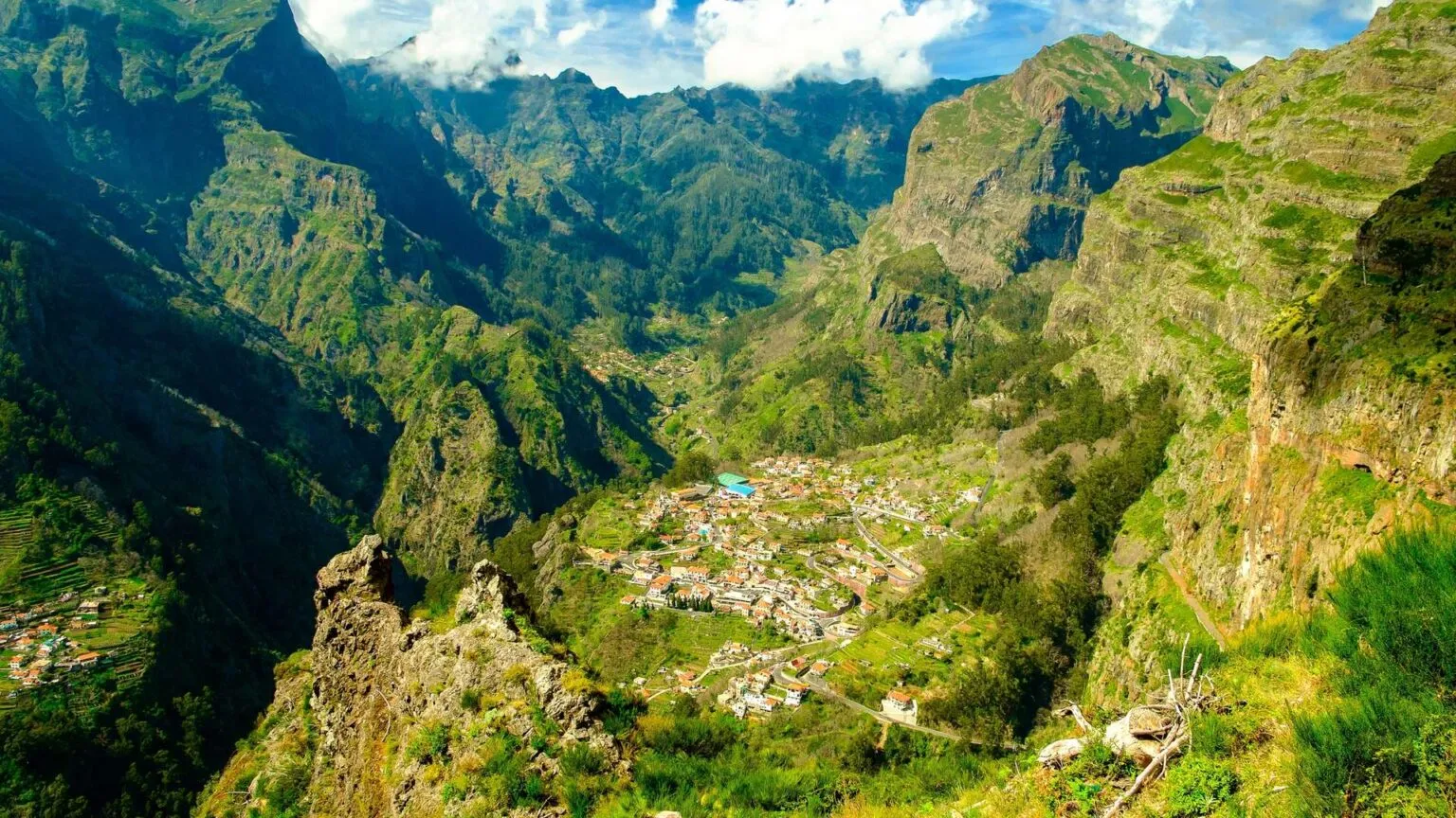 Panoramisch zicht op het geïsoleerde dorp Curral das Freiras, diep gelegen in een groen dal omgeven door steile bergwanden op Madeira.