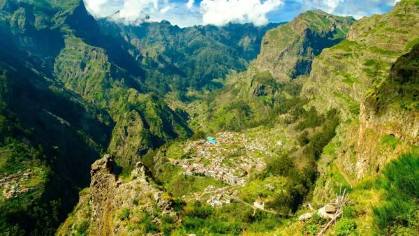 Panoramisch zicht op het geïsoleerde dorp Curral das Freiras, diep gelegen in een groen dal omgeven door steile bergwanden op Madeira.