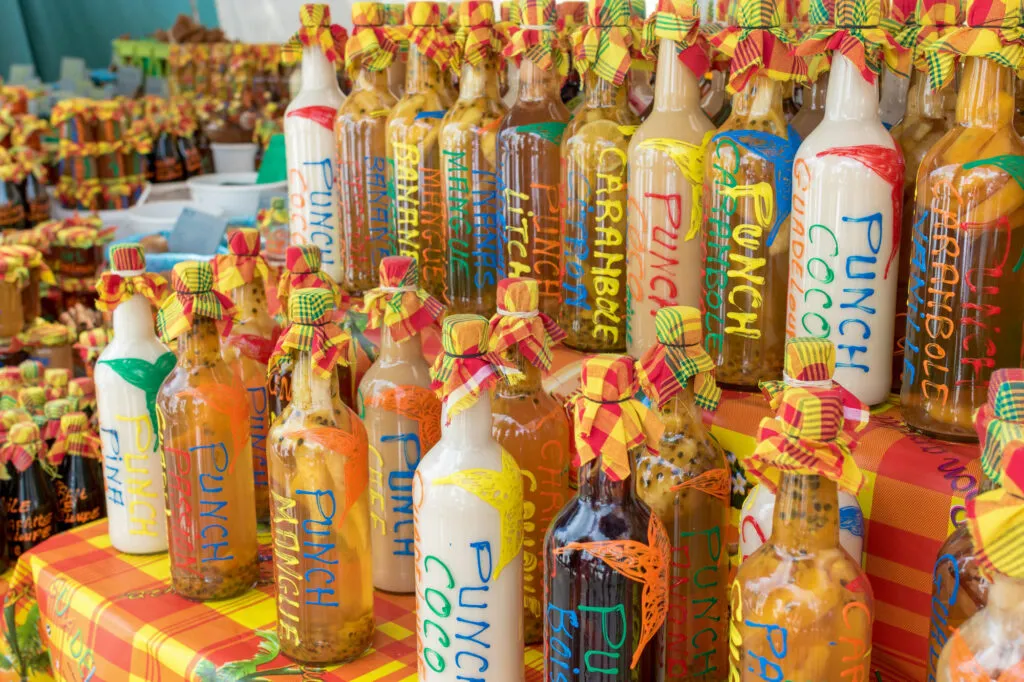 Een marktkraam op Martinique staat vol met lokaal gemaakte flessen kleurrijke punch en drank.