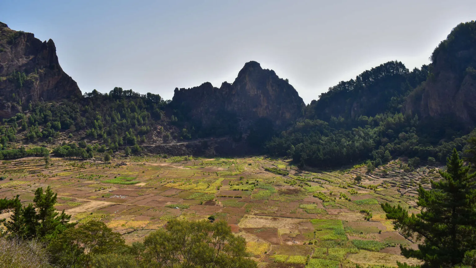Uitzicht over de groene landbouwvelden in de Paúl-krater met spitse bergen op de achtergrond op het eiland Santo Antão.