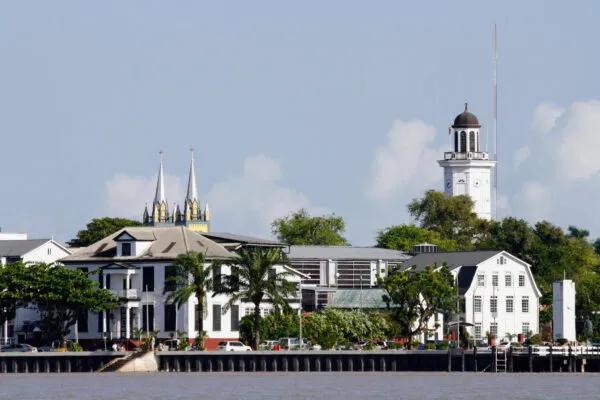Zicht vanaf het water op de houten kolonialen gebouwen, de Kathedraal en de skyline langs de oever van Paramaribo in Suriname.