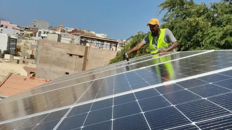 Een lokale monteur installeert zonnepanelen op het dak van een van Voja's accommodaties op het eiland Santiago