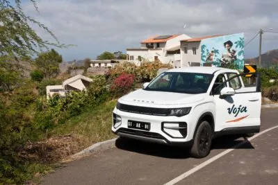 Een elektrische auto van Voja met op de achtergrond het binnenland van het eiland Santiago