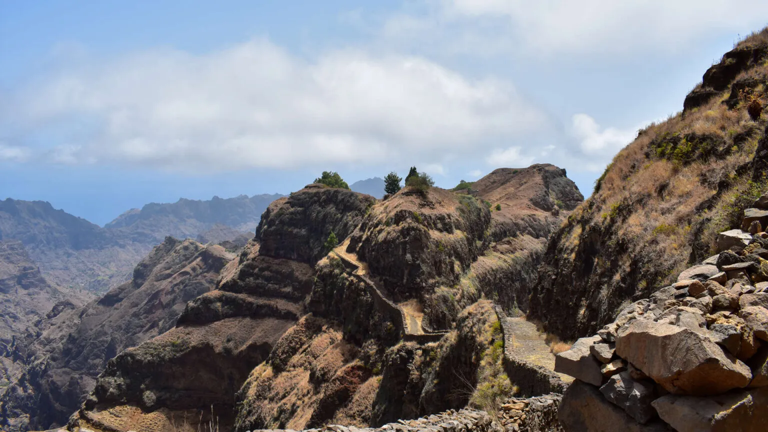 Indrukwekkende, steile rotswanden en bergtoppen onder een licht bewolkte blauwe lucht bij Caibros op het eiland Santo Antão, Kaapverdië.