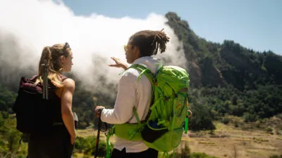 Een lokale gids en een vrouwelijke reiziger kijken uit op het landschap van de binnenlanden van eiland Santo Antão, Kaapverdië