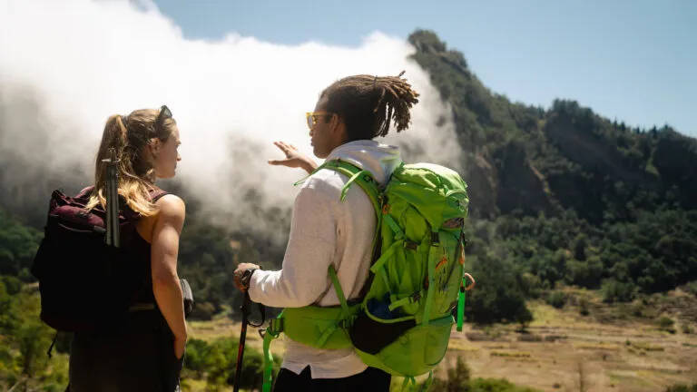 Een lokale gids en een vrouwelijke reiziger kijken uit op het landschap van de binnenlanden van eiland Santo Antão, Kaapverdië