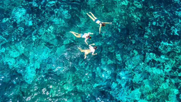 snorkelende mensen in een blauwe heldere zee