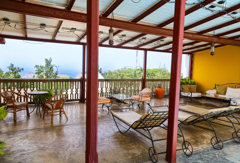 Het overdekte dakterras van Vince & Luisa's Boetiekhotel, met zitjes, ligbanken en uitzicht op São Filipe