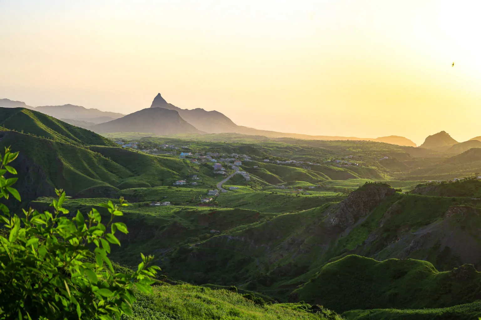Een panoramisch uitzicht tijdens een roadtrip over groene heuvels en bergen op het eiland Santiago in Kaapverdië bij zacht zonlicht.