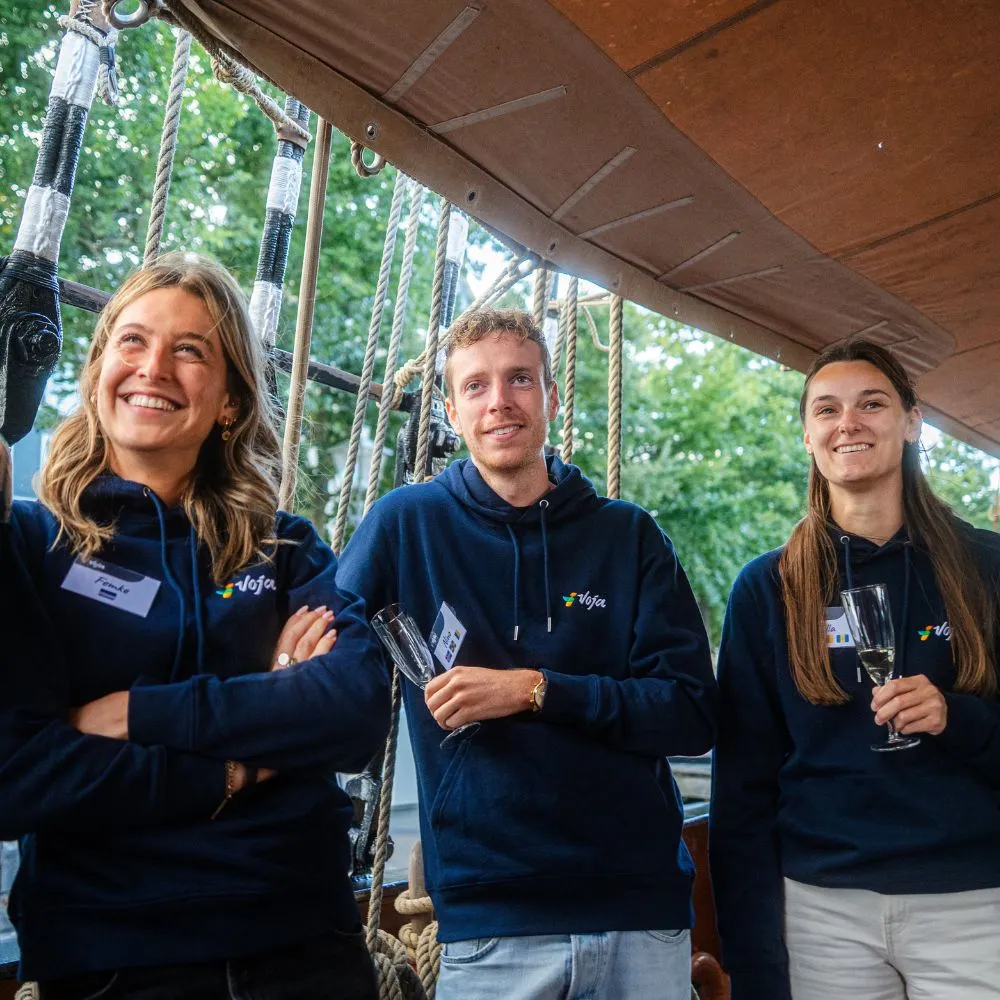 Portretfoto van vier Voja-medewerkers in hoodies met Voja-logo tijdens het Voja Captain's dinner op zeilschip De Oosterschelde in september 2025.