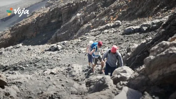 Still van drie reizigers die de Pico do Fogo beginnen uit een video van die vulkaanbeklimming