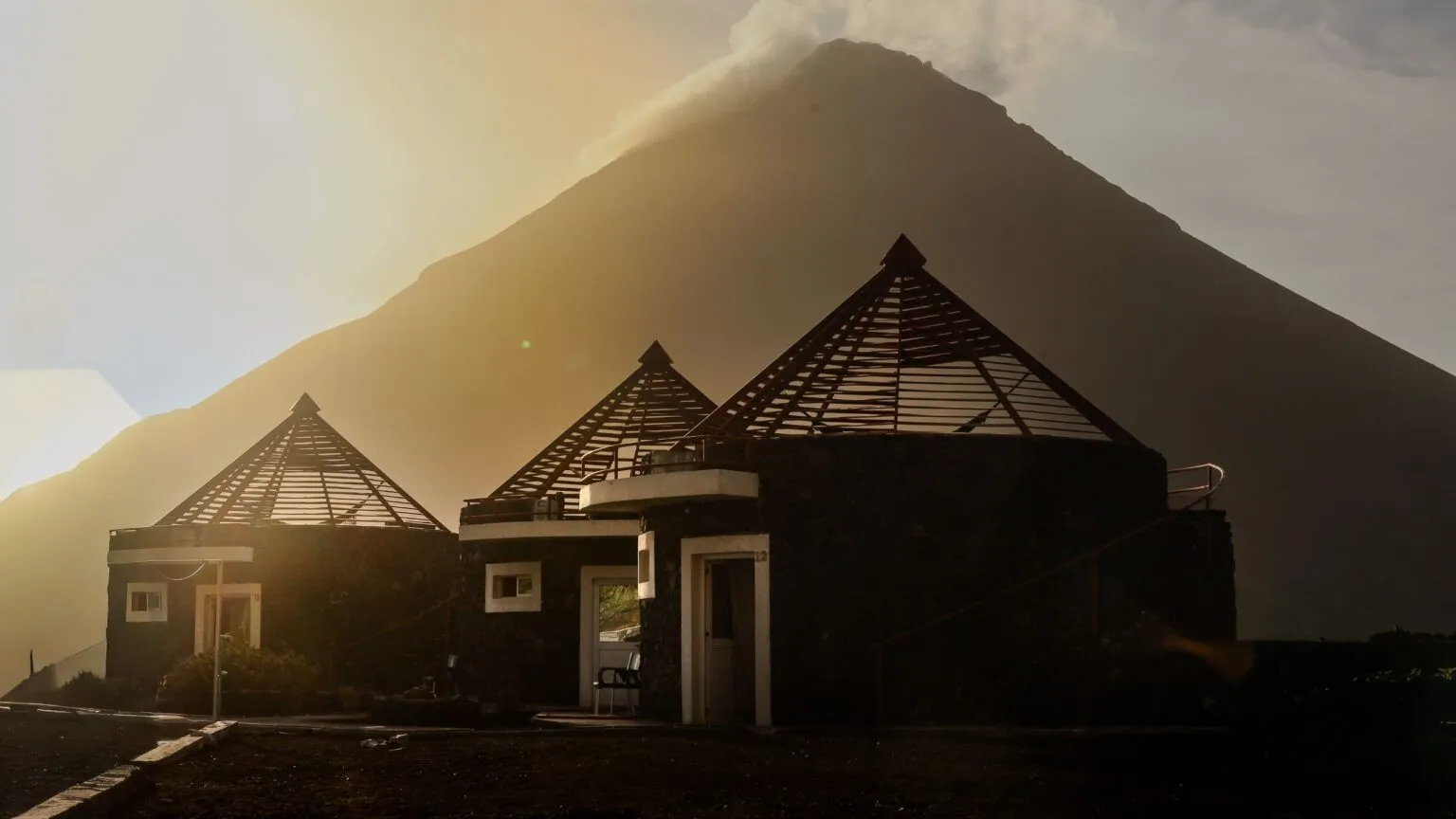Traditionele funku's, huisjes van lavasteen, met de Pico do Fogo op de achtergrond in Chã das Caldeiras