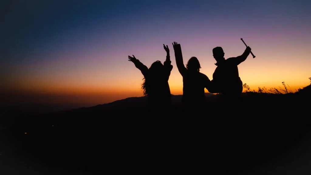 Wandelaars die dansen tijdens de zonsondergang op hun wandelreis in Kaapverdie