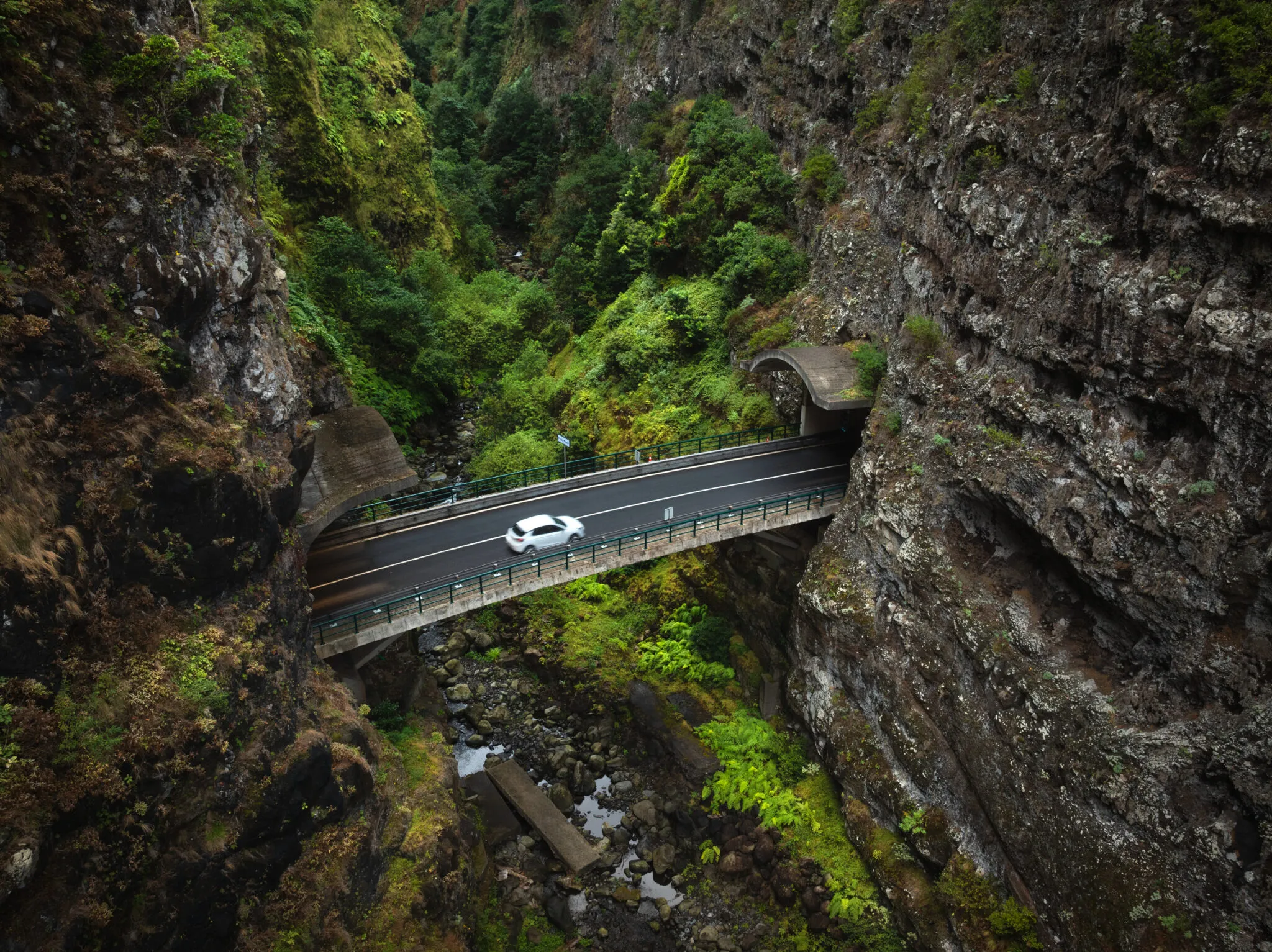 Witte auto die door de binnenlanden van Madeira rijdt