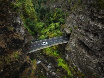 Witte auto die door de binnenlanden van Madeira rijdt